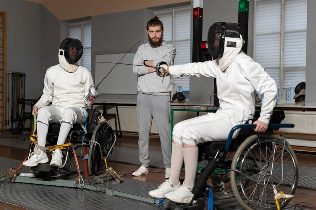 휠체어에서 싸우는 특수 장비의 장애인 펜싱 선수