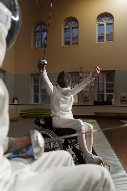 Schermitori disabili in attrezzatura speciale che combattono dalle loro sedie a rotelle
