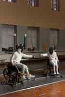 Free photo disabled fencers in special equipment fighting from their wheelchairs