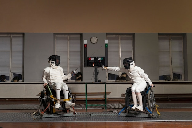 Free photo disabled fencers in special equipment fighting from their wheelchairs