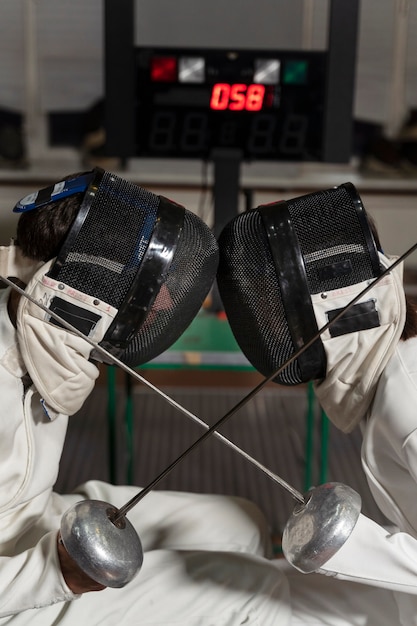 Free photo disabled fencers in special equipment fighting from their wheelchairs