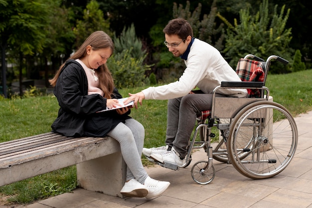 Человек-инвалид помогает девушке учиться