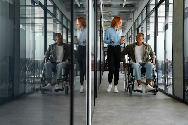 무료 사진 사무실에서 일하는 휠체어를 탄 장애인