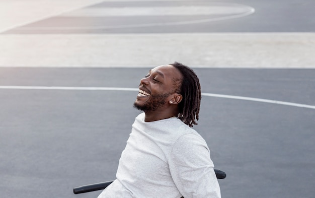 Free photo disabled man in wheelchair playing basketball