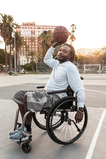 Человек-инвалид в инвалидной коляске играет в баскетбол
