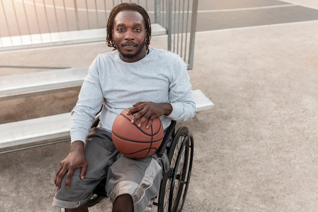 Disabled man in wheelchair playing basketball