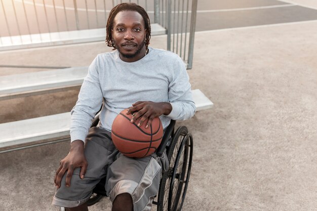 Человек-инвалид в инвалидной коляске играет в баскетбол