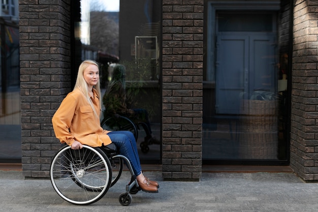 Foto gratuita persona disabile in sedia a rotelle per strada