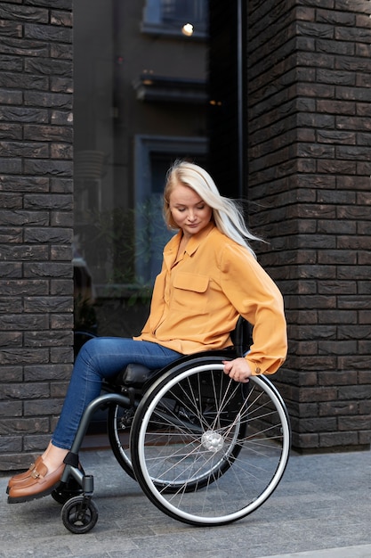 Foto gratuita persona disabile in sedia a rotelle per strada