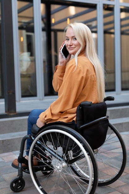 Foto gratuita persona disabile in sedia a rotelle per strada