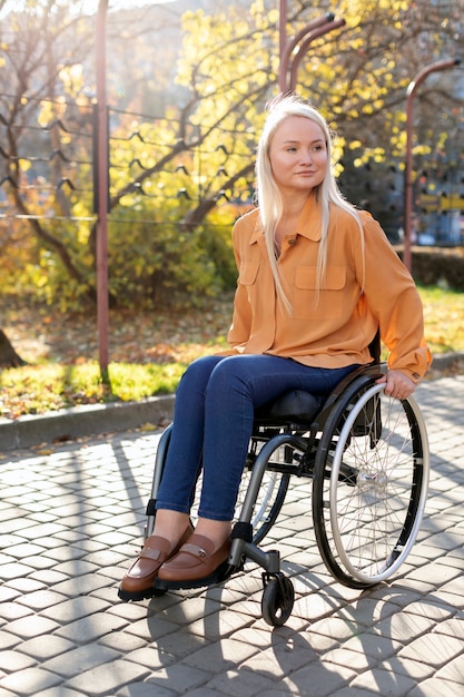 Foto gratuita persona disabile in sedia a rotelle per strada