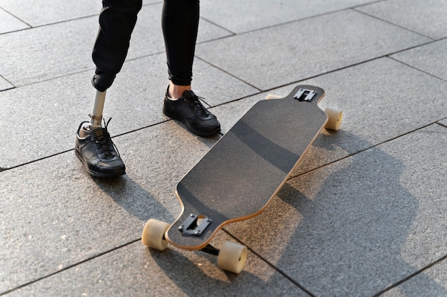 Foto gratuita persona disabile con skateboard all'aperto