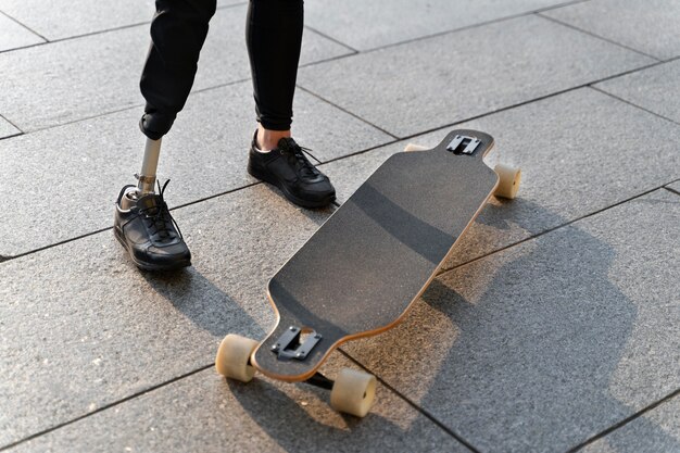 屋外でスケートボードを持っている障害者