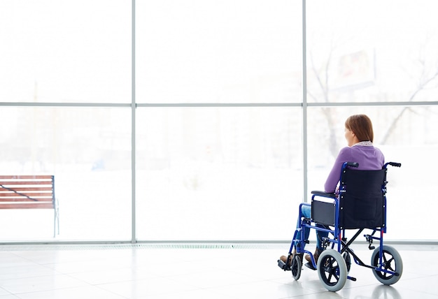 Disabled woman looking at window