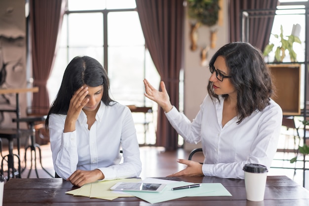 Disappointed business woman scolding colleague. 