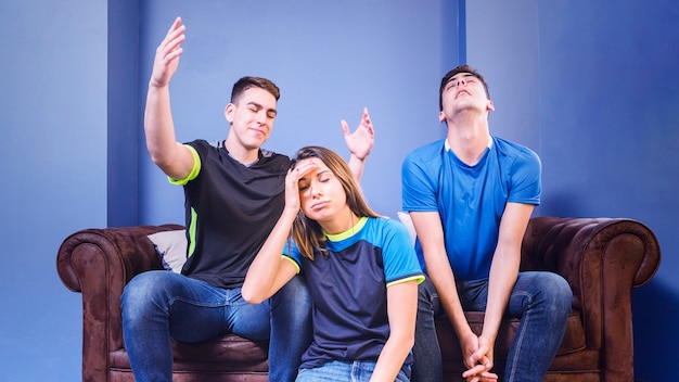 Free photo disappointed football fans on couch