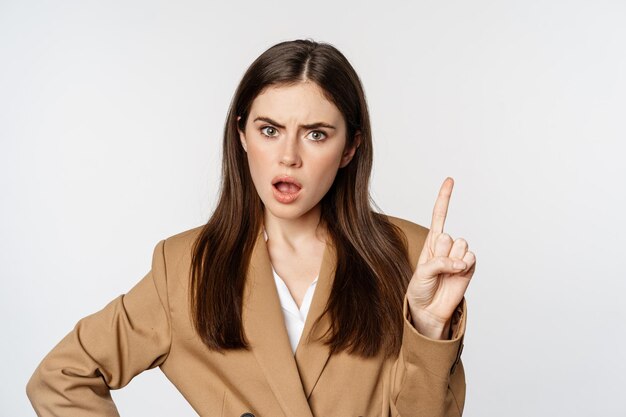 Disappointed lady boss, business woman shaking finger taboo sign, decline, prohibit something, disagree, standing over white background