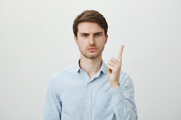 Disappointed male employer scolding worker, shaking finger displeased