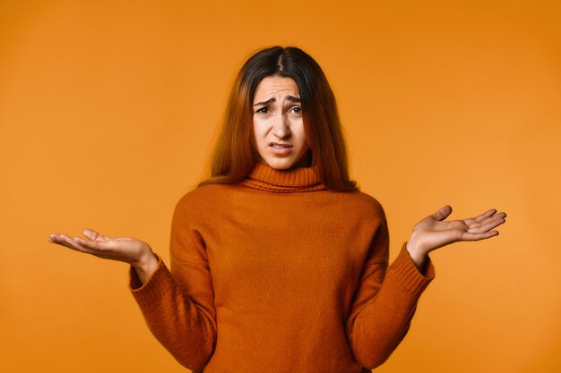 Disappointed redhead caucasian woman dressed in wool pullover