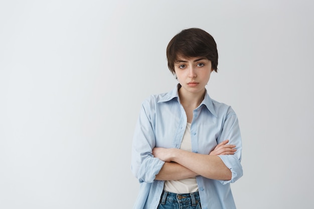 Disappointed and skeptical young tomboy girl cross arms chest and looking judgemental