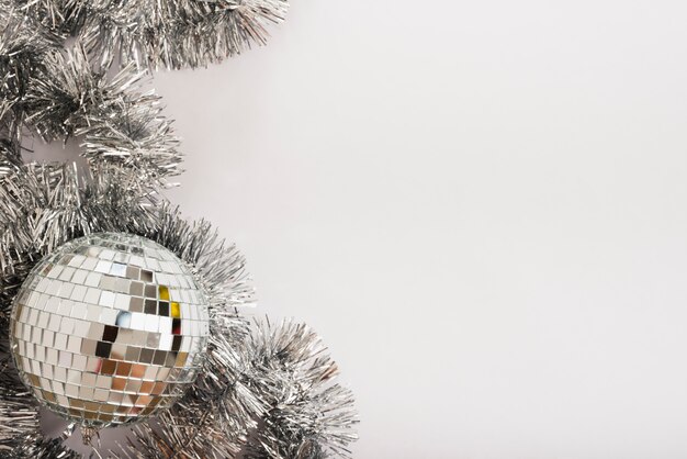 Disco ball with tinsel on white table 