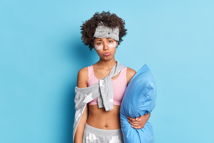 Free Photo discontent dark skinned young woman with afro hair looks sadly at camera wants to sleep