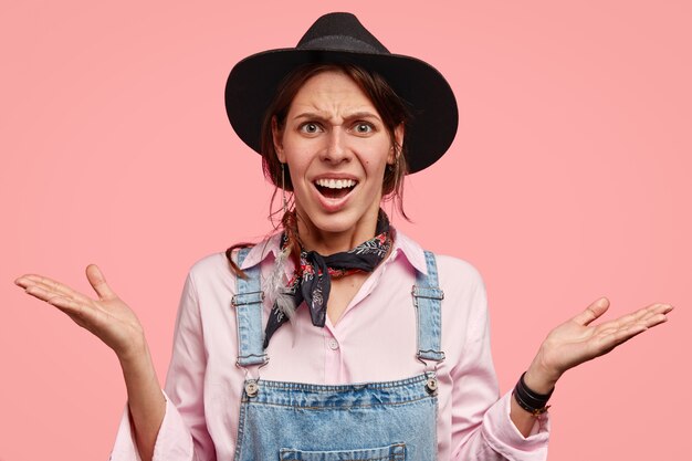 Discontent indignant female agricultural worker shrugs shoulders in bewilderment