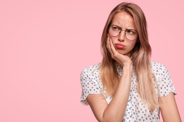 Discontent thoughtful Caucasian female has grumpy expression