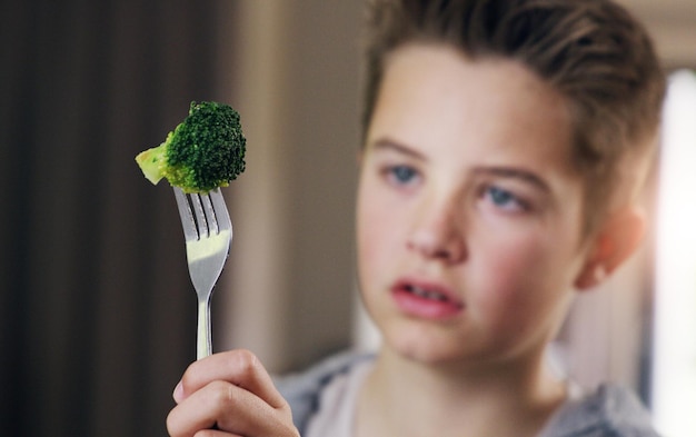 Free photo disgust food and refuse with child and broccoli for nutrition health and cooking sad angry and dinner with boy and green vegetable on fork at home for eating problem frustrated and dislike