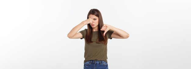 Disgusted young blonde closing her nose with her fingers isolated over white background