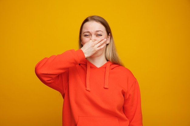 Disgusted young blonde woman doing bad smell gesture 