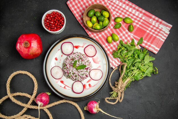 a dish a dish of redish seeds of pomegranate citrus fruits green