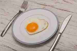 Free photo dish with cutlery and a fried egg