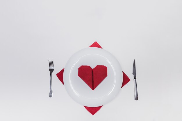 dish with cutlery and a heart-shaped napkin