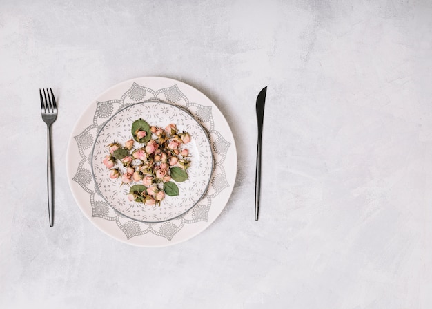 Dish with flowers between cutlery