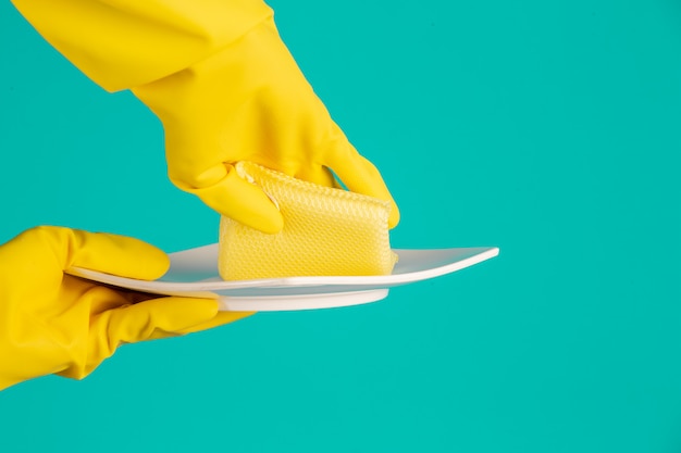 Free photo dishwasher wearing yellow gloves on a blue .