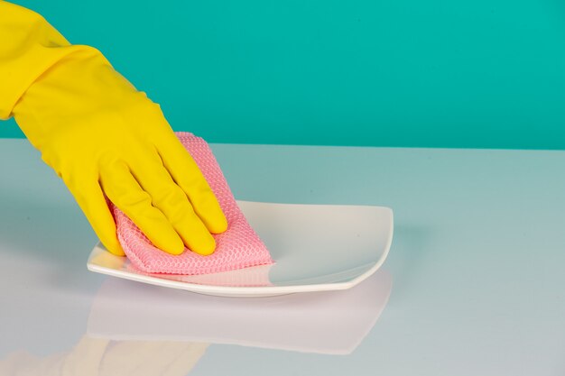 Dishwasher wearing yellow gloves on a blue