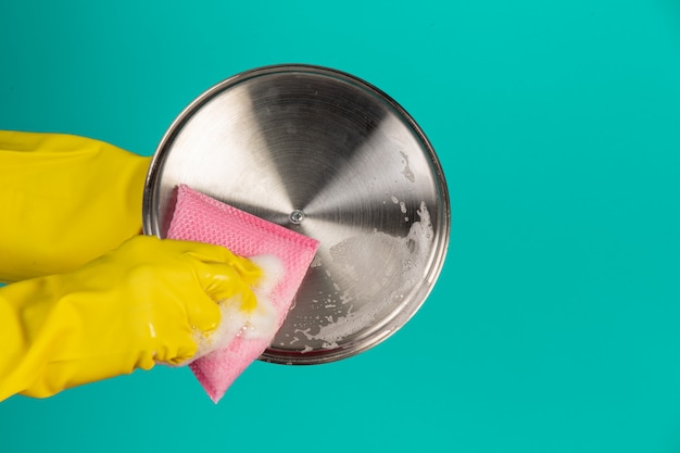 Free photo dishwasher wearing yellow gloves on a blue .