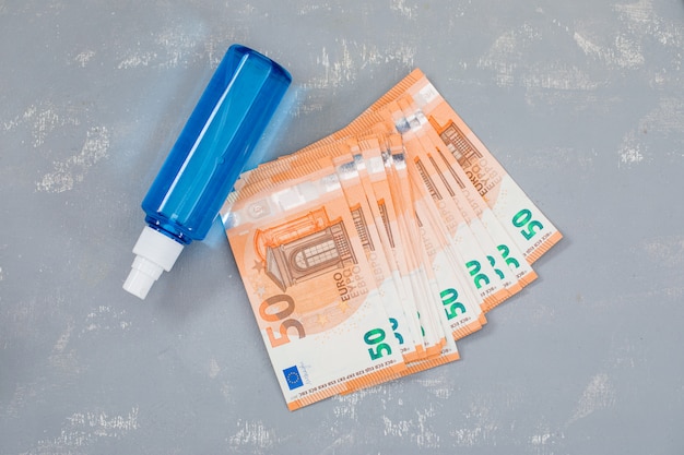 disinfectant spray, banknotes on plaster table .