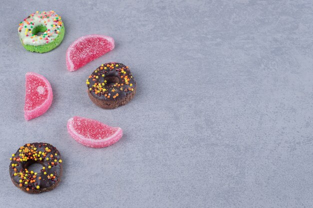 Display of donuts and marmelades on marble surface