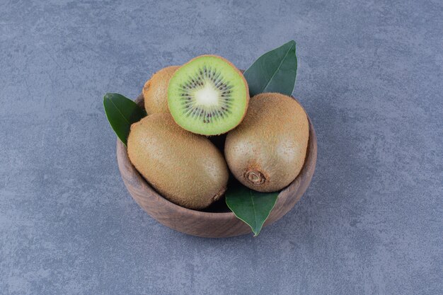 A display of kiwi fruits in bowl on the dark surface