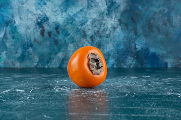 Free photo a display of ripe persimmon , on the marble table.