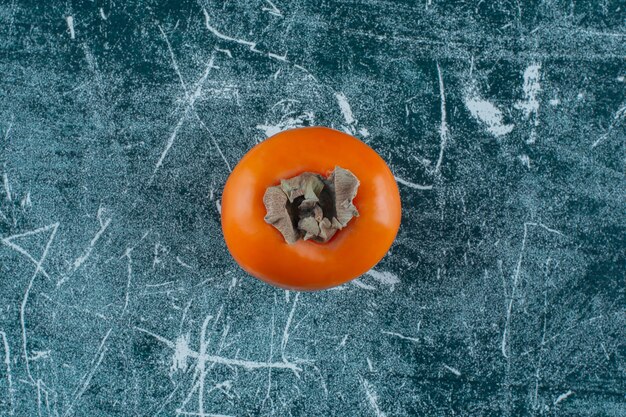A display of ripe persimmon , on the marble table. 