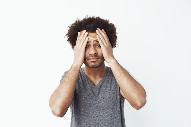 Free photo displeased african man grab his face with hands.