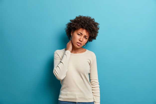 Free photo displeased afro american woman touches neck