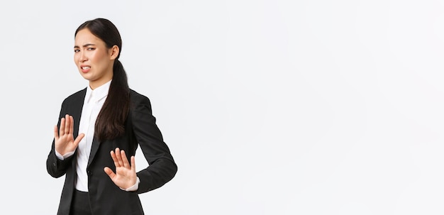 Displeased asian businesswoman avoiding risky suggestions shaking hands in refusal rejecting disgusting strange offer Saleswoman grimacing from aversion and step away white background