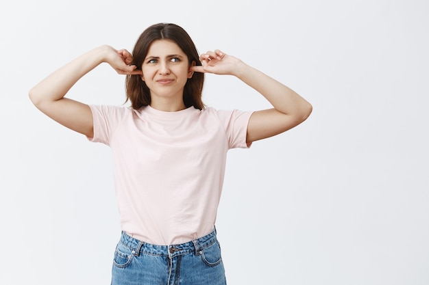 Displeased and bothered young brunette posing