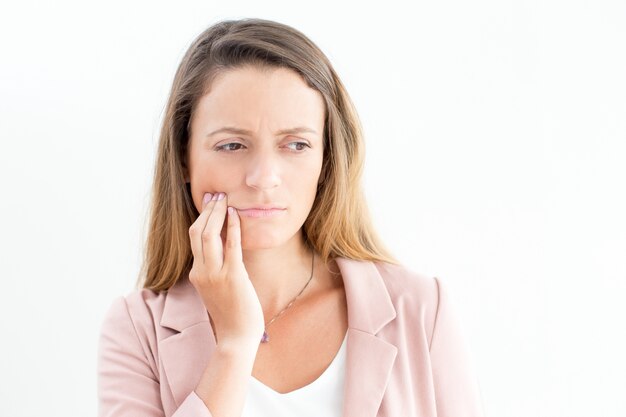 Displeased businesswoman suffering from toothache