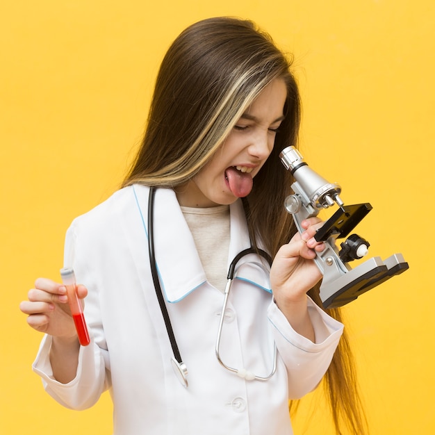 Free photo displeased girl looking through microscope