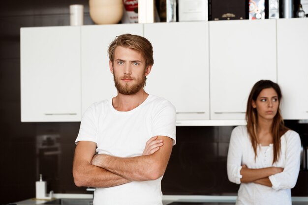 Displeased handsome man in quarrel with his girlfriend 